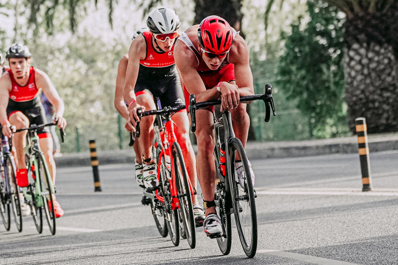 services-02 Full body of group of athletes in sportswear and protective helmets riding bicycles during competition